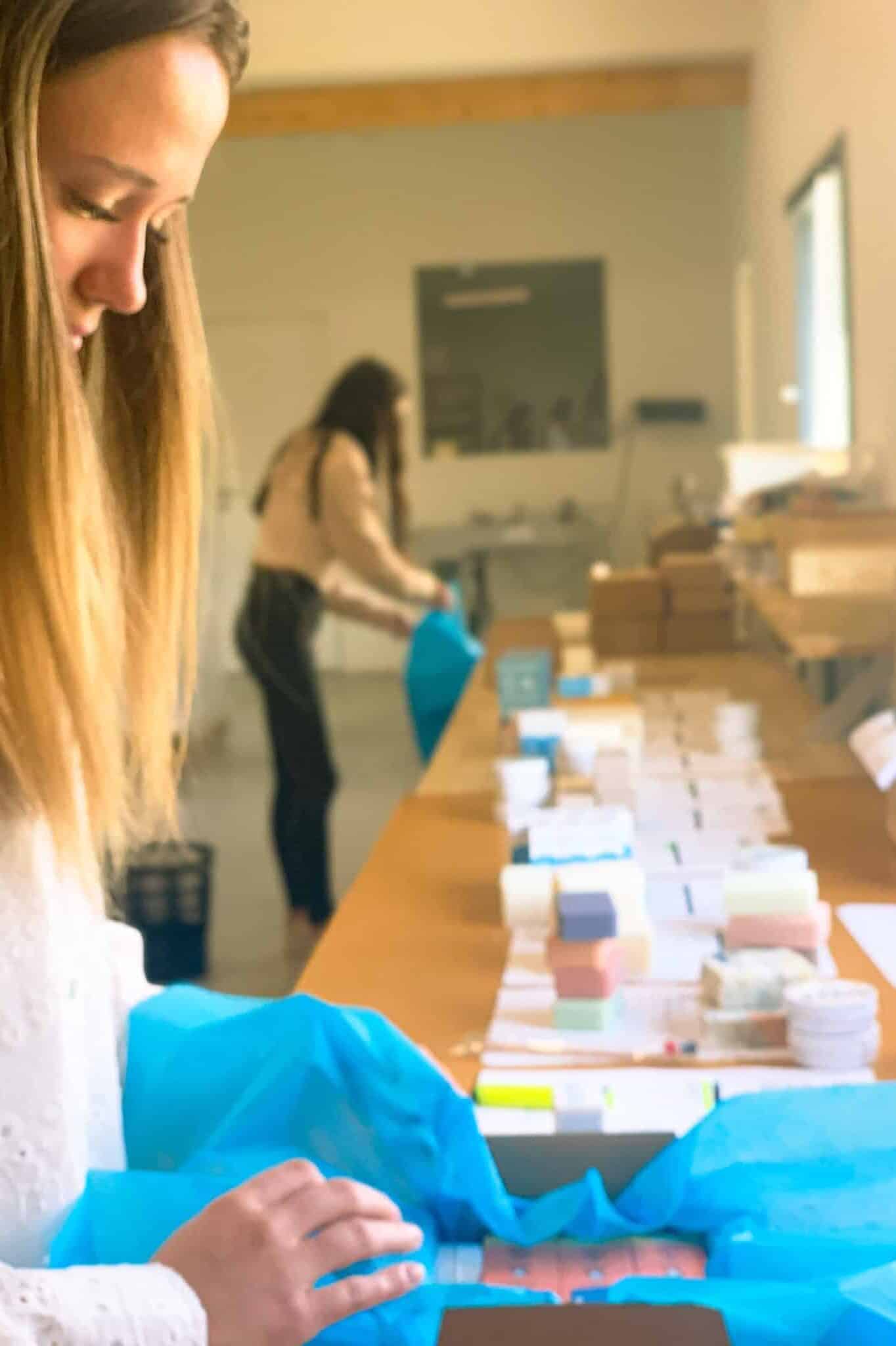 Femmes emballant des produits dans un atelier lumineux.